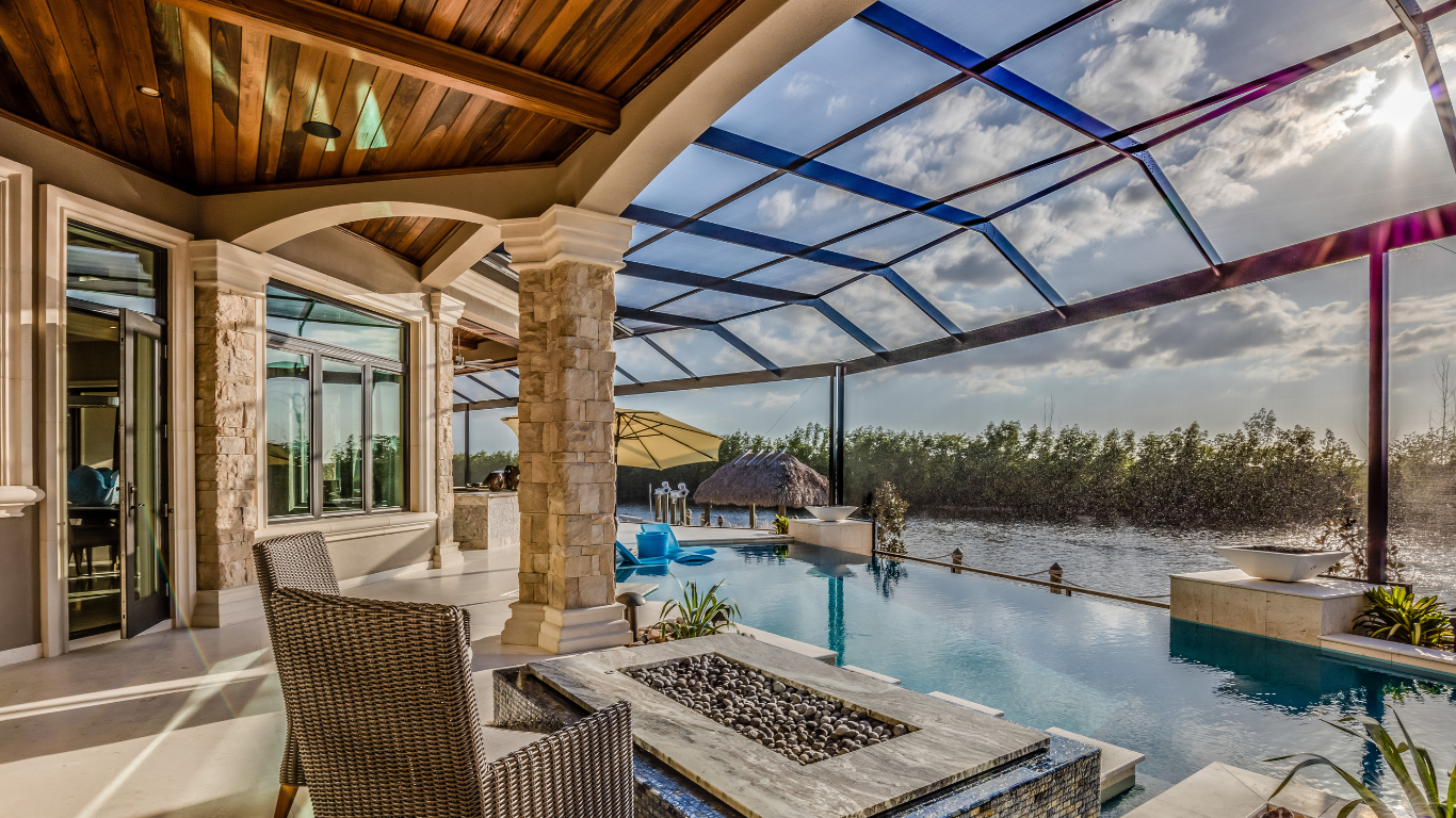A beautiful custom pool cage encloses a pool overlooking the river.