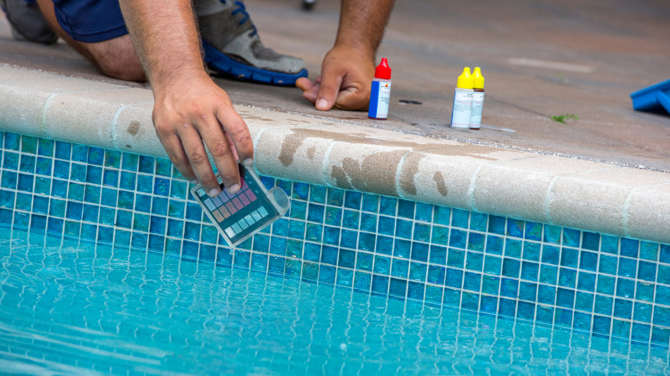A man collects water to test a sample of his pool water to ensure the chemicals are in alignment. 