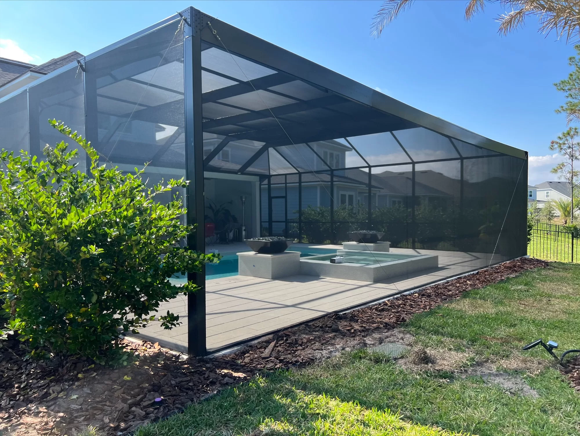 A freshly cleaned and treated pool that is protected by a screen enclosure built by Screen Enclosures and more in Jacksonville, Florida.