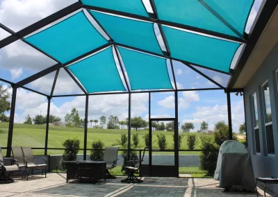 A screened-in patio has shade sails on top to prevent the harsh sun and heat from entering their enclosed patio space.