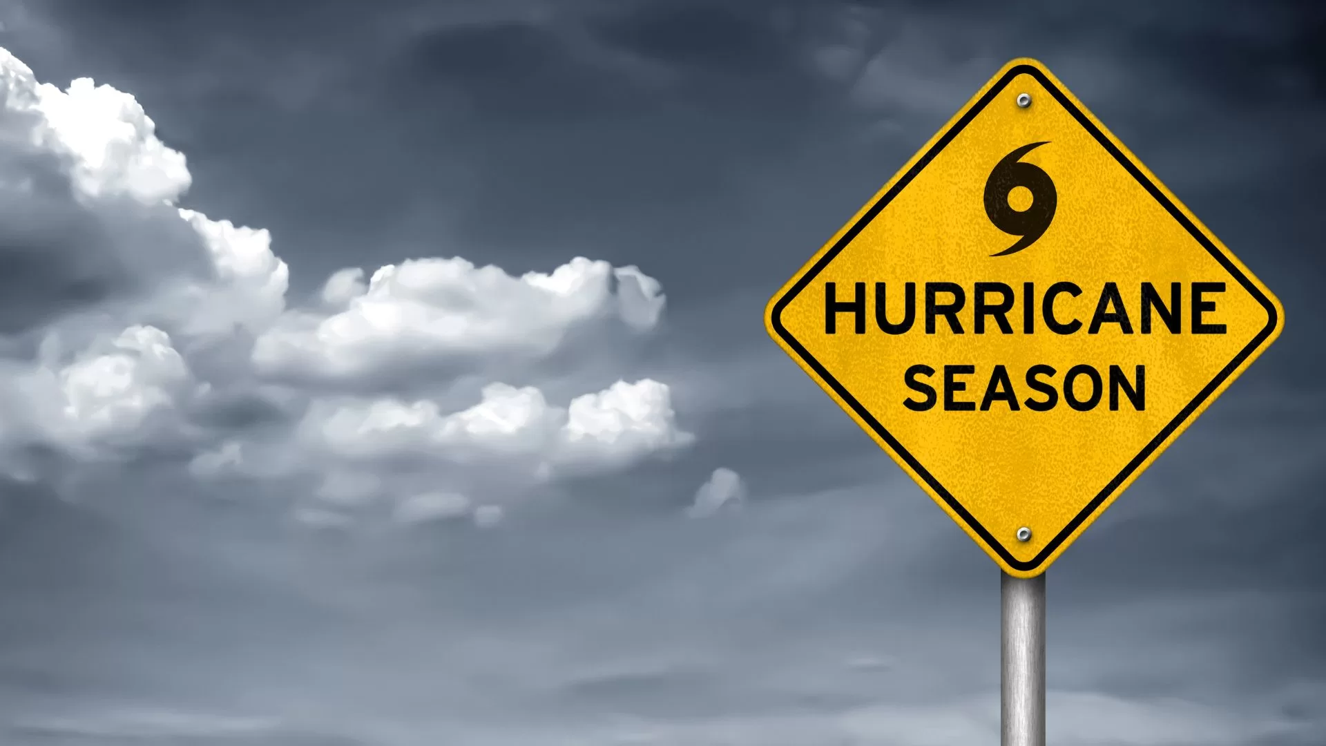 a sign that says hurricane season is in front of a cloudy sky. 