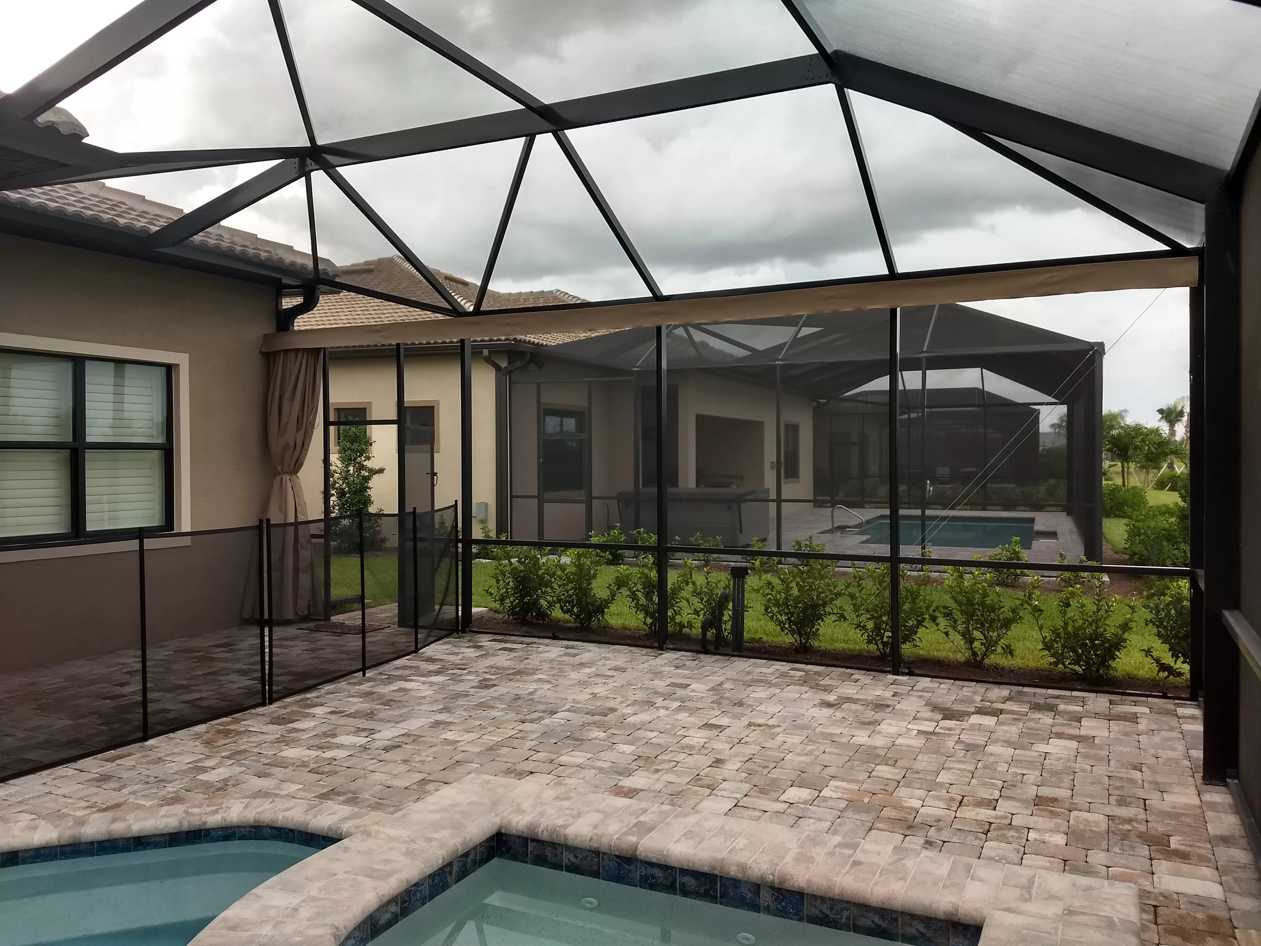 A beautiful screen enclosure covered a pool and patio area.
