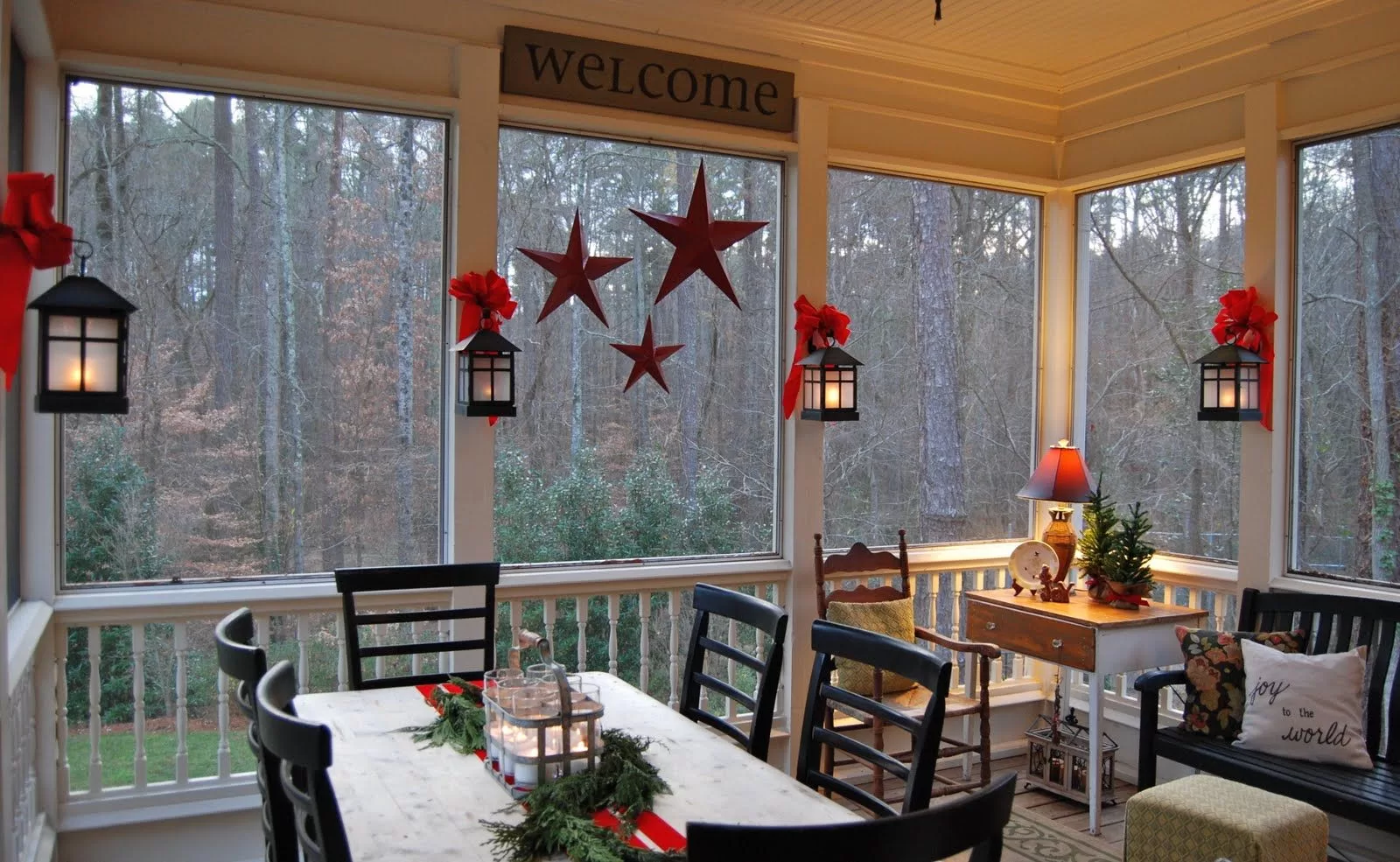 this screened in porch is illuminated with lanterns that give is a warm glow during a chilly night. 