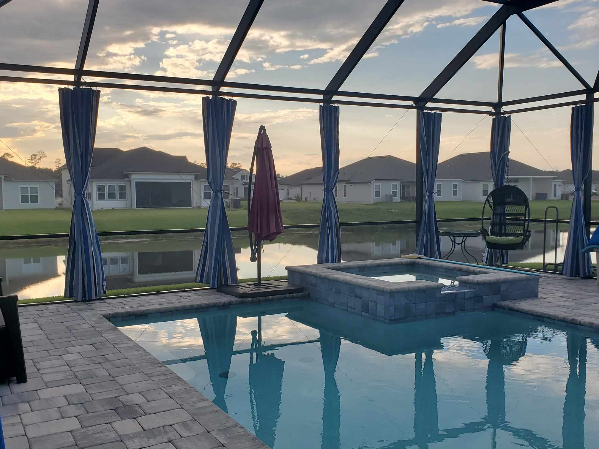 These beautiful pool cage curtains are open so the homeowner can take in the beautiful Jacksonville, Florida sunset.