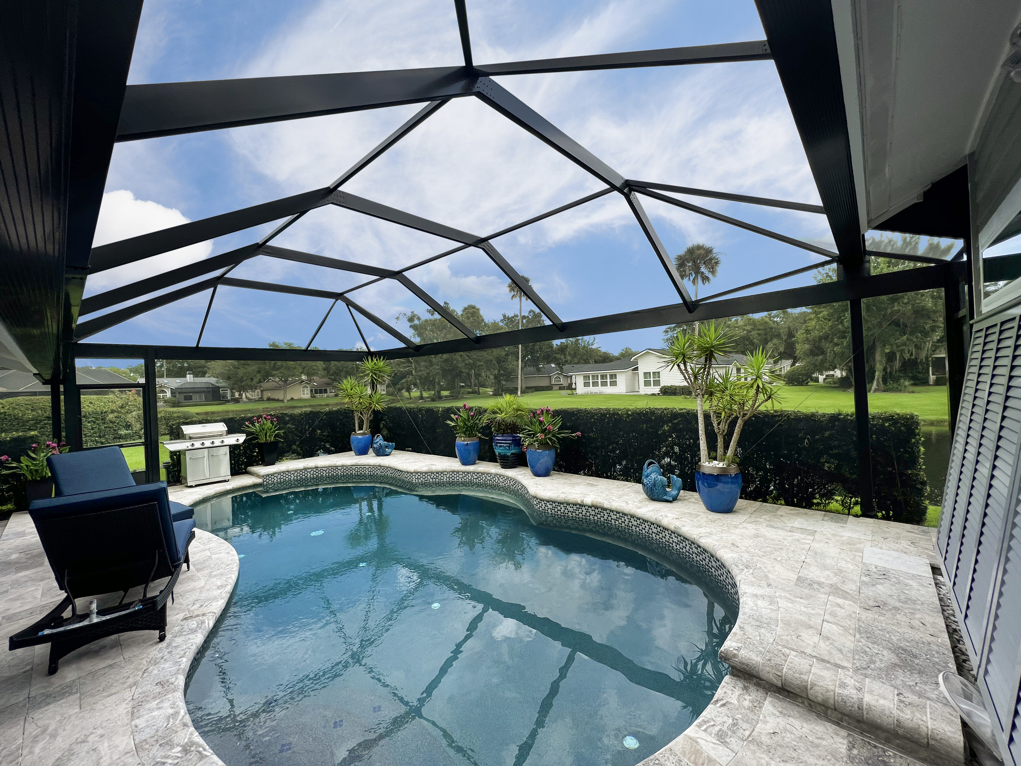 A custom screen enclosure providing a shield against the elements, allowing you to enjoy your outdoor space regardless of rain, wind, or intense sunlight.