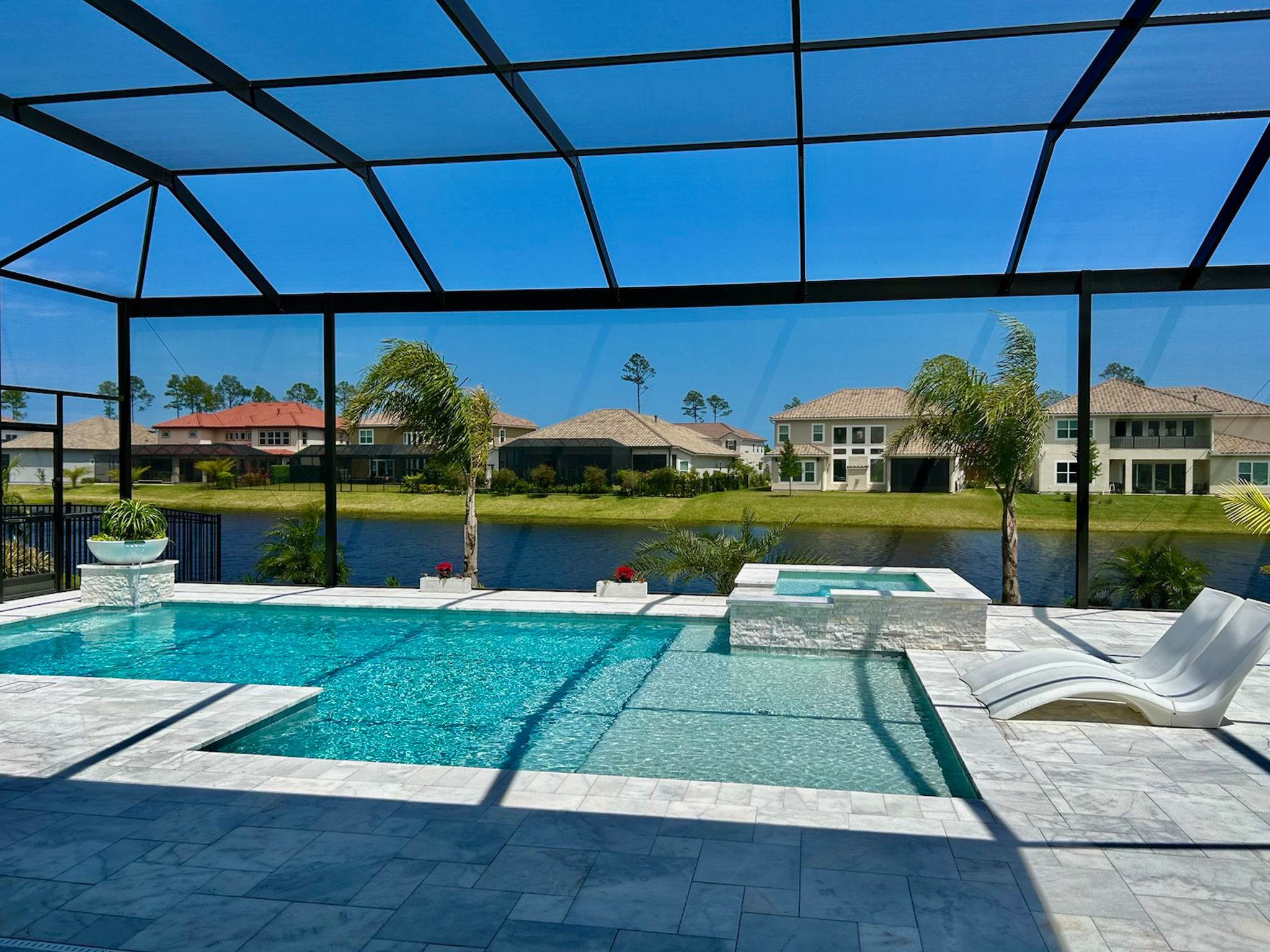 A tropical pool in Jacksonville Florida with a UV protective pool screen enclosure made by Screen Enclosures and More.